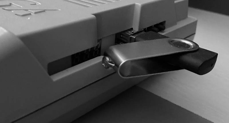 A Gotek drive fitted in an A500, with a USB stick inserted.